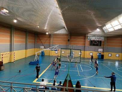 Interior del pabellón deportivo con cancha de baloncesto y espectadores