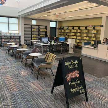 Interior del área de lectura con mesas y sillas modernas