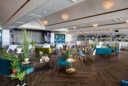 Interior del salón de eventos con decoración moderna y mesas preparadas