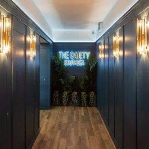 Pasillo de entrada con letrero luminoso 'The Gaiety Southsea'
