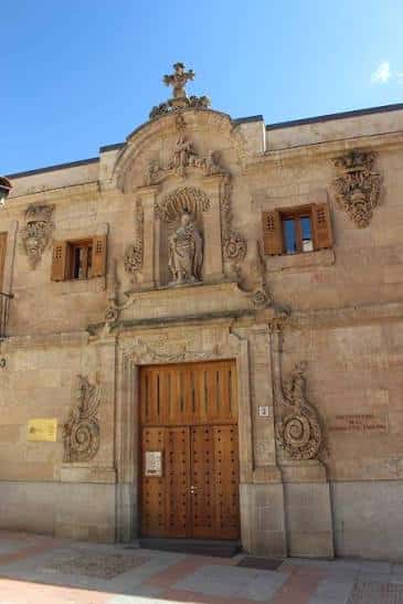 Fachada principal del Centro Documental de la Memoria Histórica con puerta de madera y escultura central