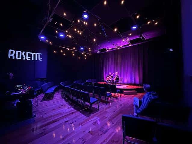 Interior del teatro The Rosette con iluminación escénica y público sentado