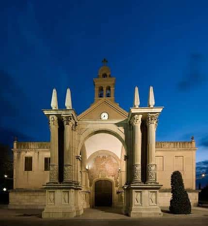 Fachada iluminada del Santuari de Misericòrdia al atardecer, destacando sus columnas y campanario