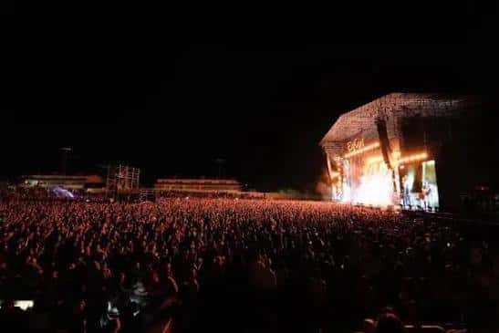 Concierto nocturno con gran multitud frente al escenario en el Estadio José Copete