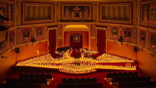 Interior del auditorio del Ateneo decorado con velas para evento cultural
