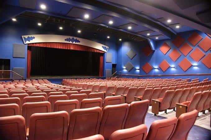 Interior del auditorio con butacas rojas y escenario