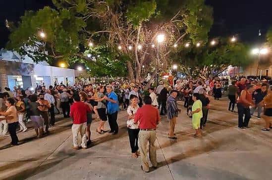 Evento social nocturno en el Parque de Santiago con luces decorativas y personas bailando