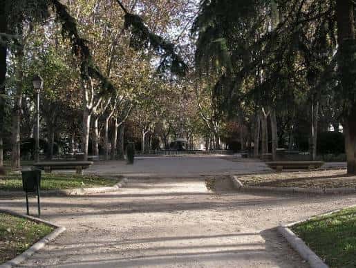 Sendero interior del parque con bancos y árboles frondosos