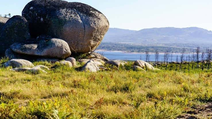 Formaciones graníticas junto a un río en el paisaje natural de Ourense