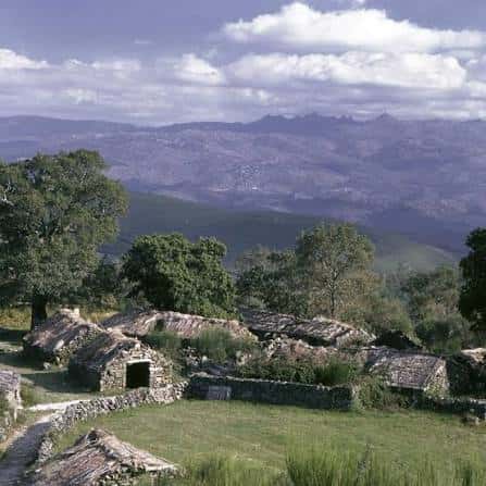 Paisaje rural con construcciones tradicionales de piedra y vistas a las montañas
