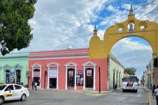 Arco de entrada colorido en el Parque de San Juan con edificios coloniales a los lados
