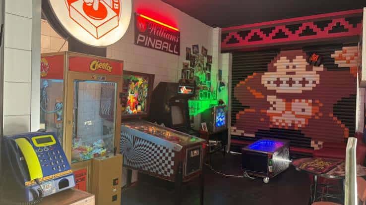 Interior del Arcade Club Almería con máquinas recreativas retro y decoración temática