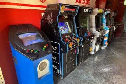 Fila de cabinas de videojuegos clásicos en el interior del local