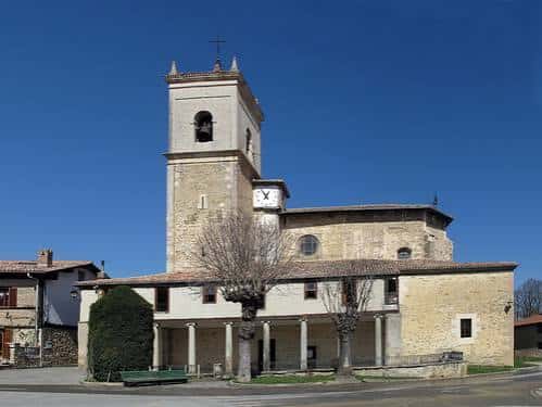 Iglesia de Aberasturi con fachada de piedra y campanario bajo cielo azul