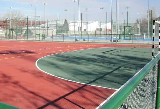 Cancha multiusos con superficie roja y verde para deportes urbanos