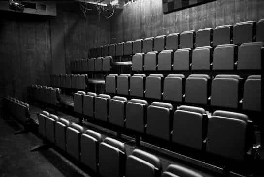 Interior del auditorio con butacas en gradas y ambiente oscuro