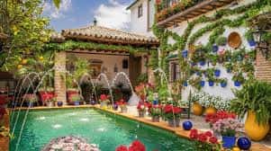 Patio tradicional con fuente central, azulejos y vegetación exuberante