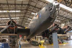 Interior del hangar mostrando bombardero histórico en restauración