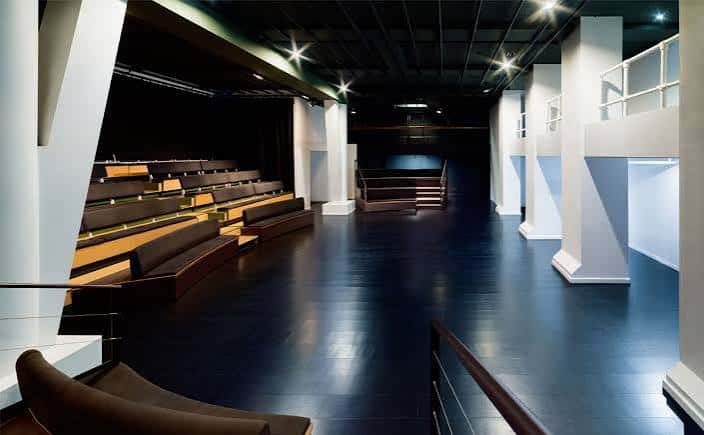 Interior del auditorio con iluminación moderna y diseño arquitectónico