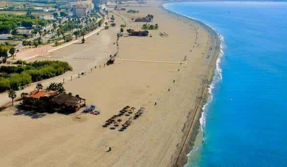 Vista aérea de una extensa playa en Motril con arena dorada y mar azul