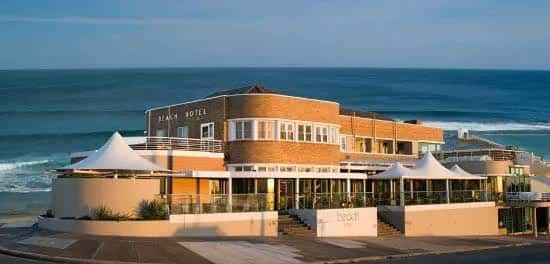 Fachada del Beach Hotel frente al mar con olas rompiendo