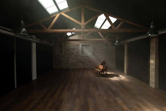 Interior del teatro con piano y techo de vigas de madera