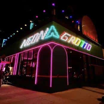 Fachada exterior de Neon Grotto iluminada con neón multicolor