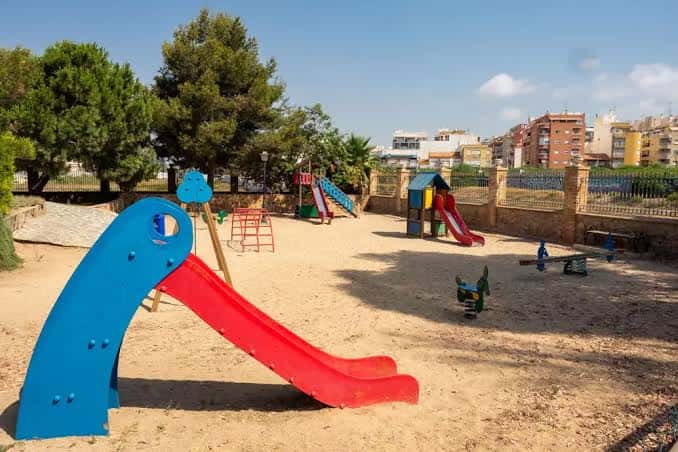 Zona de juegos infantiles con toboganes y columpios