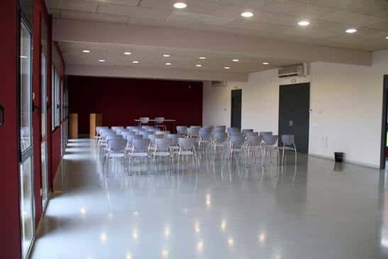 Sala interior preparada para eventos con sillas dispuestas