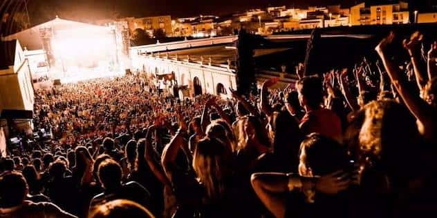 Público disfrutando del concierto desde la grada con el escenario al fondo