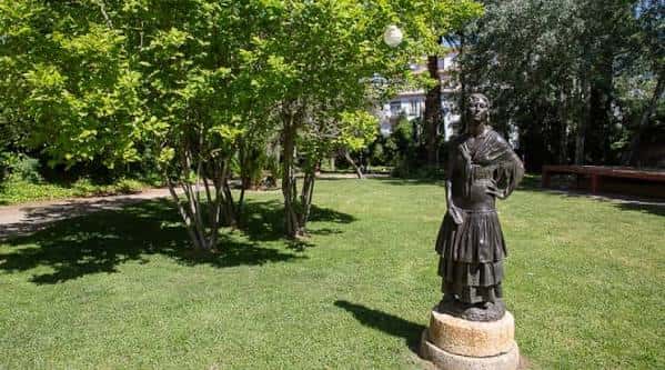 Jardín con estatua y árboles frondosos en el Museo Pedrilla