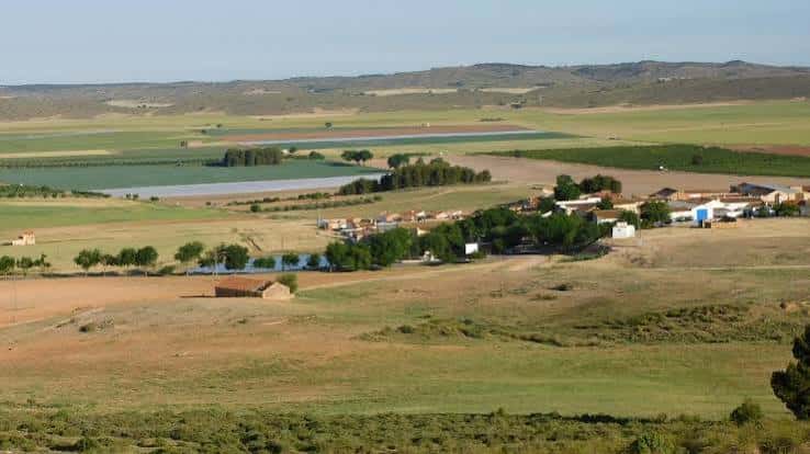 Panorámica del pueblo de Campillo de las Doblas rodeado de campos agrícolas y colinas