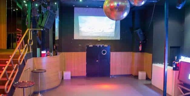 Interior de la sala Pirandello con barra de madera y proyector