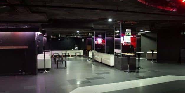 Zona de lounge con sofás blancos y mesas en la sala Pirandello