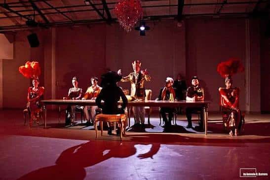 Escenario iluminado con actores en una puesta en escena teatral