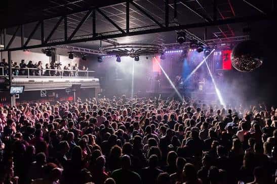 Interior del Industrial Copera con multitud de asistentes y escenario iluminado