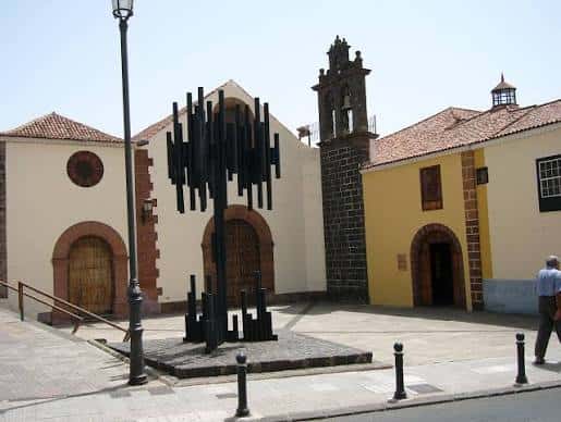 Plaza frente a la Ermita de San Roque con escultura moderna