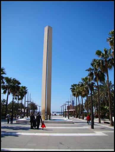 Plaza de las Velas bajo un cielo azul despejado, con personas caminando junto al obelisco