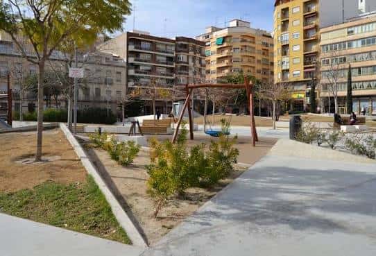 Vista general de la Plaza Séneca con zona de juegos infantiles y edificios residenciales al fondo