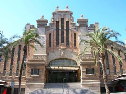 Fachada principal del Mercado Central de Alicante con arquitectura modernista y palmeras