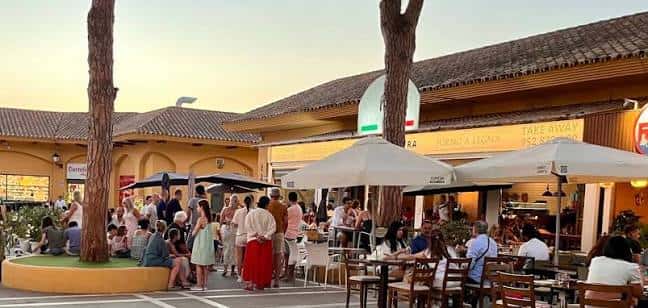 Vista exterior del Centro Comercial Elviria con terrazas de restaurantes y gente disfrutando al atardecer
