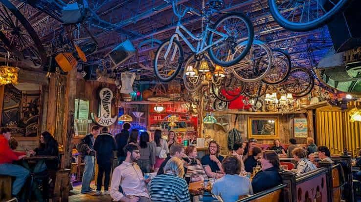 Interior acogedor del restaurante con bicicletas colgando del techo y ambiente animado
