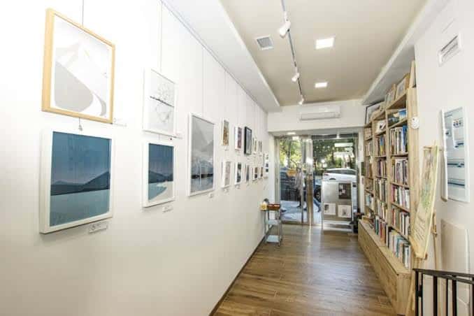 Interior de la librería y galería con obras expuestas en las paredes