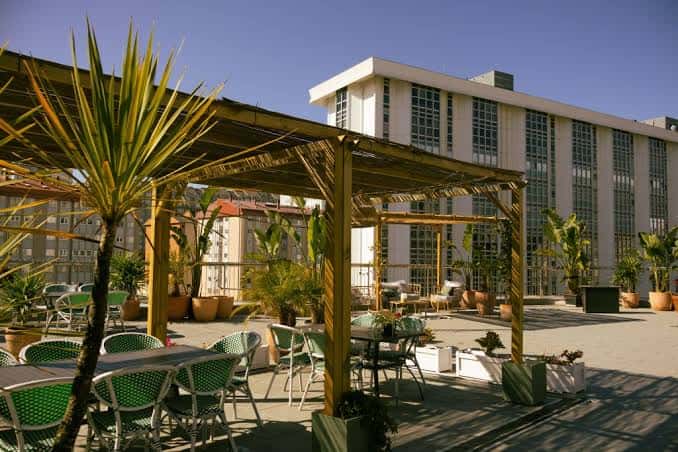 Terraza exterior del Bellini Rooftop con pérgola de madera y plantas