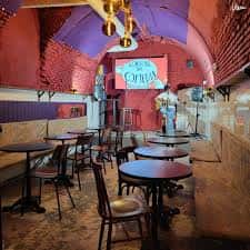 Interior del Jíbaro Café Bar con mesas y sillas en un ambiente acogedor