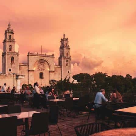 Vista panorámica desde la terraza con la Catedral de Mérida al fondo durante el ocaso