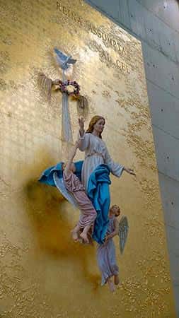 Detalle del retablo dorado de Santa Maria Assumpta con escultura de la Virgen y el Espíritu Santo