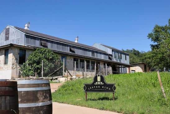 Fachada del edificio principal con barriles decorativos y cielo despejado