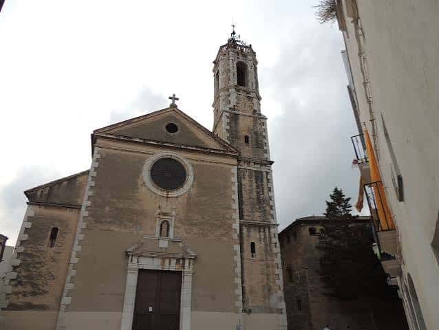 Ángulo lateral de la iglesia mostrando el campanario y detalles arquitectónicos en tonos neutros