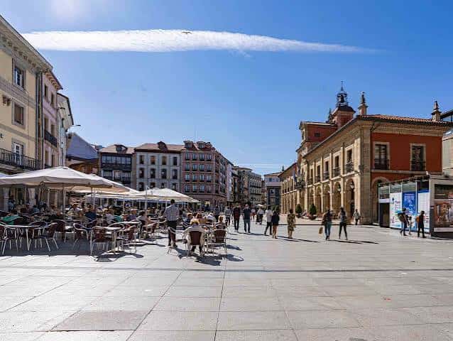 Vista panorámica de la Plaza de España en Avilés con terrazas y edificios históricos bajo un cielo despejado